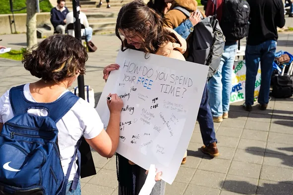 Students filling out a screen time survey poster